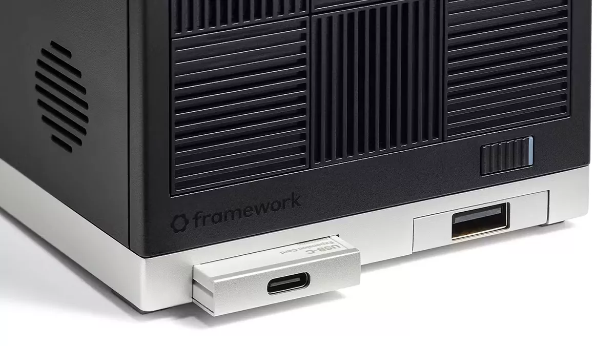 Close-up of a Framework desktop's rear, showcasing USB-C and USB-A ports, venting, and branding on a sleek black and silver design.